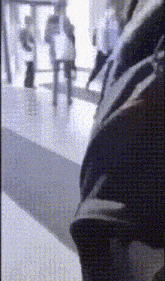 a blurry picture of people walking down a hallway .