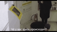 a woman standing next to a fire extinguisher and a machine that says ' che y bac ' on the bottom