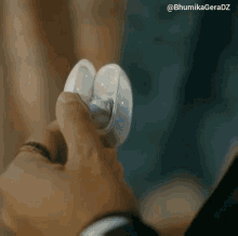 a close up of a person holding a pair of ear buds