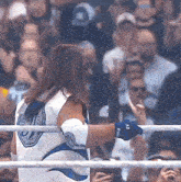a wrestler in a white and blue outfit with the letter j on the back of his shirt