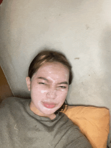 a woman with a white mask on her face laying on a bed