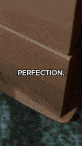 a close up of a wooden dresser with perfection written on it