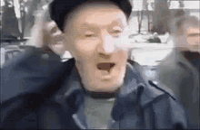 an elderly man wearing a hat and a jacket is making a funny face in a blurry photo .