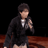 a man singing into a microphone with chinese characters on the bottom