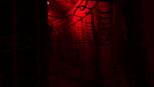 a dark tunnel with red lights on the walls and stairs
