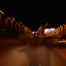 a blurred image of a car driving through a tunnel at night