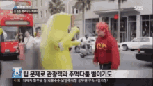 a sbs news channel shows a man in a yellow costume talking to another man