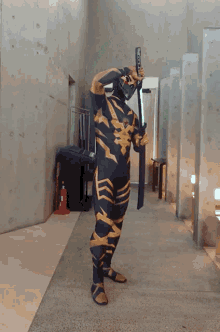a man in a costume is holding a sword in a hallway