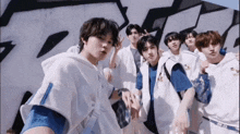 a group of young men pose for a photo in front of graffiti