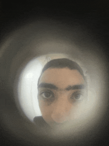 a person 's face is visible through a peephole