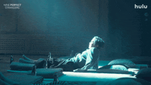 a poster for nine perfect strangers shows a person laying on a bed