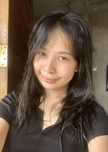a woman in a black shirt is smiling and taking a selfie