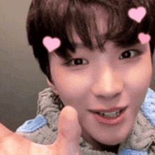 a close up of a person 's face with pink hearts on their forehead .