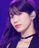 a close up of a woman wearing earrings and a choker with a cross on it