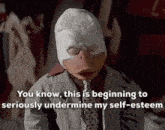a man in a suit and tie is wearing a duck mask and a tie .