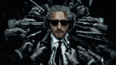 a man wearing sunglasses and headphones is surrounded by many guns