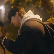 a man in a hoodie is standing next to a woman in a black jacket .