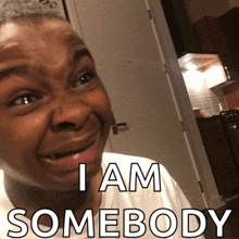 a man is making a funny face with the words i am somebody behind him