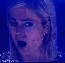 a close up of a woman 's face with a blue background and the words trash tv troll below it