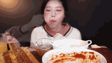 a woman is sitting at a table with plates of food and a glass of orange juice .