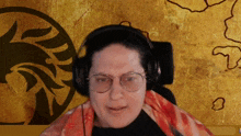 a woman wearing glasses and headphones is sitting in front of a map