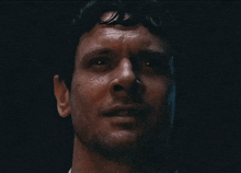 a close up of a man 's face with red eyes and sweat coming out of his nose .