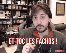 a man in front of a microphone with the words et toc les fachos written on his face