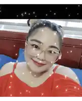 a woman wearing glasses and a red top smiles at the camera