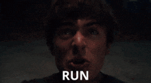 a close up of a person 's face with the word run behind him