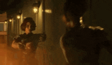 a man and a woman are standing next to each other in a dark room holding guns .