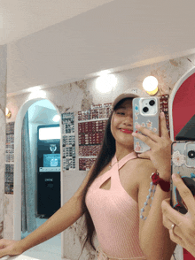 a woman taking a selfie in front of a photo booth