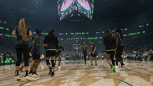 a group of female basketball players are standing on a court in front of a scoreboard that says storm vs. army