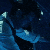 a man in a white shirt is in a dark room