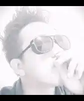 a man wearing sunglasses smoking a cigarette in a black and white photo