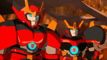 two transformers are standing next to each other and one has a blue light on his chest