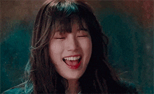 a close up of a woman smiling with her eyes closed and her mouth open .