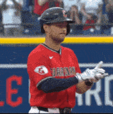 a baseball player wearing a red jersey that says guardian