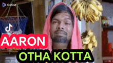 a man wearing a pink head scarf with the words aaron otha kotta on the bottom