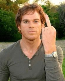 a man with a watch on his wrist giving the middle finger