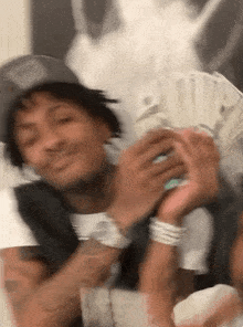 a man in a hat is holding a stack of money in his hands .