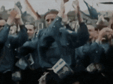 a crowd of people raising their hands in the air
