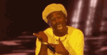 a man wearing a yellow hat and a yellow t-shirt is making a funny face .