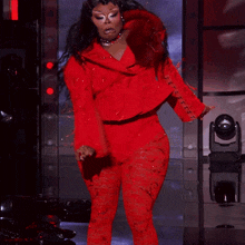 a woman in red is dancing on a stage