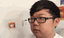 a man wearing glasses and a white shirt looks at something