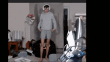 a man wearing headphones and shorts is standing in a room