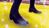 a pair of black boots standing on a yellow carpet