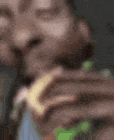 a blurry picture of a person holding a piece of food in their hand .