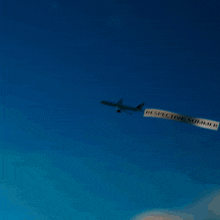 a plane is flying through a blue sky with smoke coming out of the wing