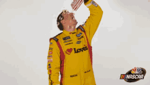 a man in a yellow racing suit is holding a book that says love on it