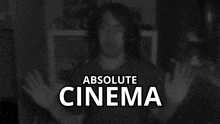 a black and white photo of a man with the words " absolute cinema " behind him